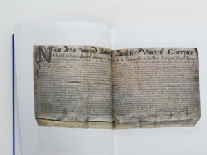Double page du livre Bévilard dans l'Histoire comportant une archive manuscrite de Jean Voirod. notaire, et Vincent Cherpier, justicier daté de 1717.