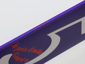 Tranche de la Brochure du Prix Emilie Gourd — sur la tranche violette est inscrit le prix Emilie Gourd a 5 ans  dans la police de caractère Sectra de Grilli Type et en couleur orange.