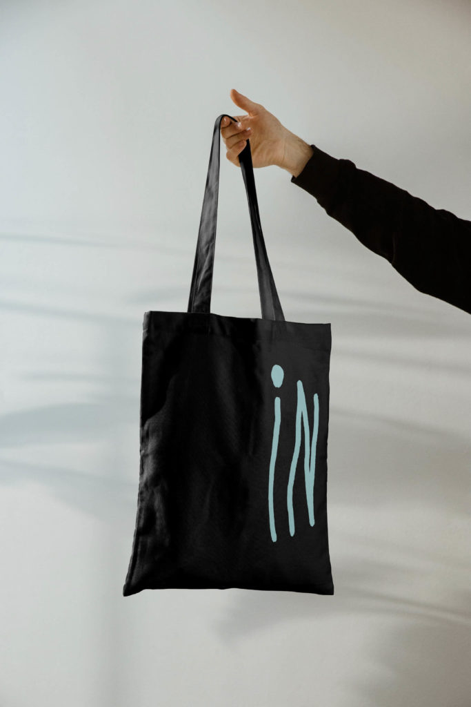 Tote bag pour Inouïe, agence pour artistes, avec le logo décliné sur les deux faces du sac de toile