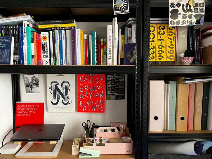 Détails de l'espace atelier de la graphiste Ludivine Cornaglia à Genève. Quelques ouvrages de graphisme et édition ainsi que l'habillage dessiné de la vitrine du studio.